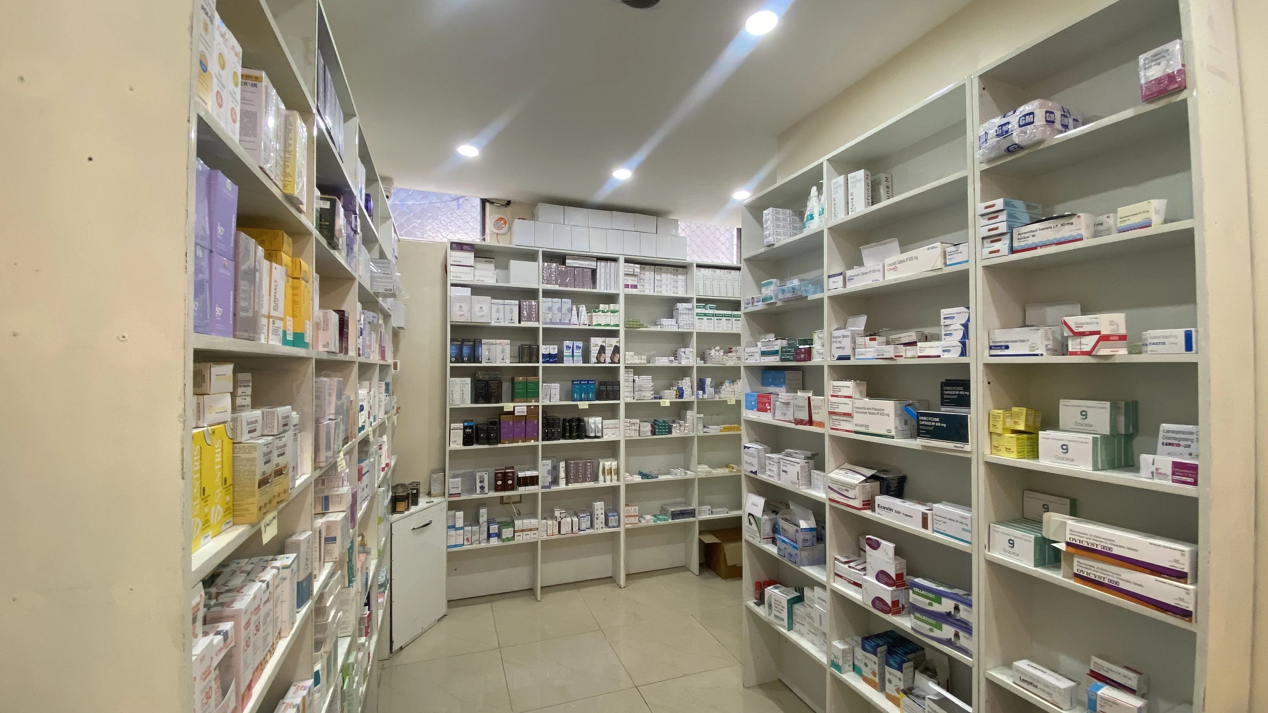 Stocked pharmacy shelves with dermatology and skincare products