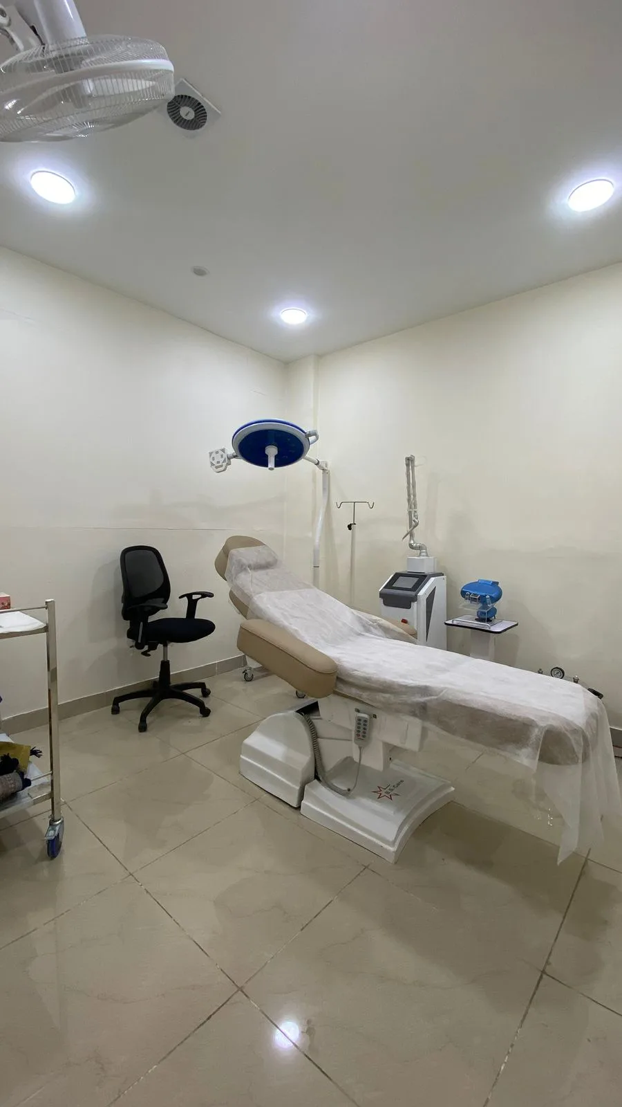 Procedure room with motorised aesthetic bed, surgical light and CO2 laser arm