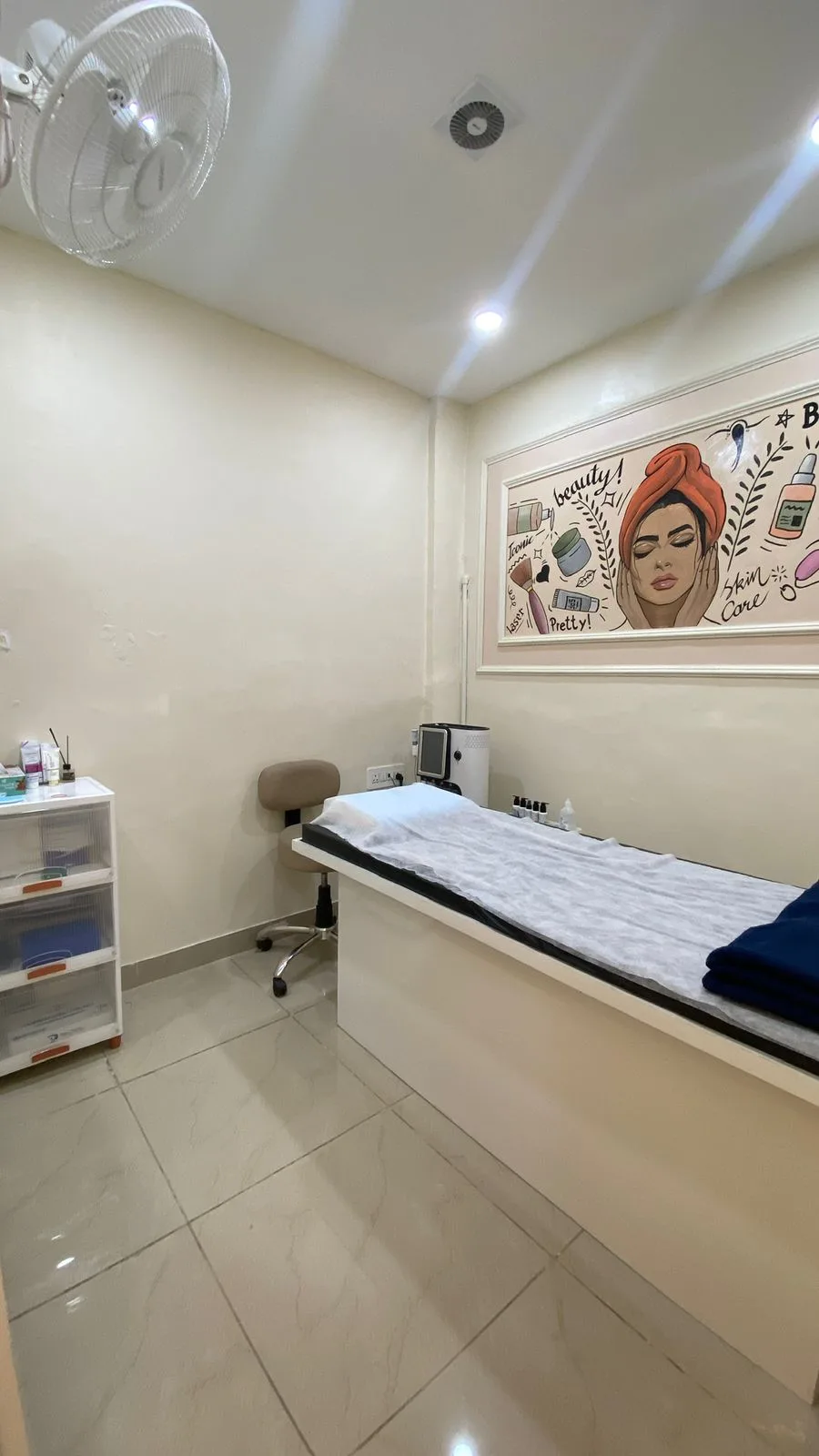 Skin care treatment room with beauty mural and aesthetic treatment bed